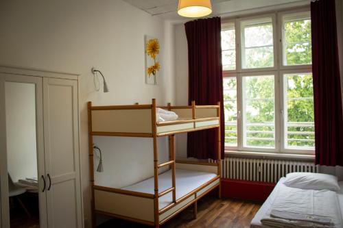 柏林柏林大都会酒店的一间卧室设有两张双层床和一扇窗户。