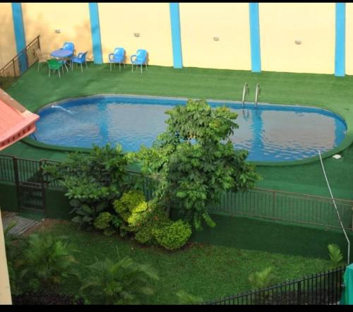 伊巴丹Ibadan Serviced Apartments的庭院内的游泳池,配有桌椅