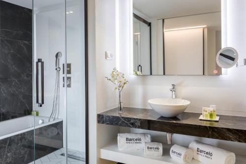 马德里易美吉因巴塞罗酒店&度假村的一间带水槽和玻璃淋浴的浴室