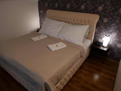 利贝雷茨拉德尼斯酒店的一间卧室配有一张床,上面有两条毛巾