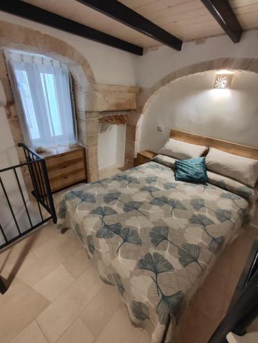 普蒂尼亚诺Archi Antichi的一间带床的卧室,位于带窗户的房间内