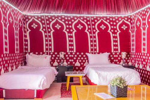 达赫拉Hotel WOW的一间设有两张床和红色墙壁的客房