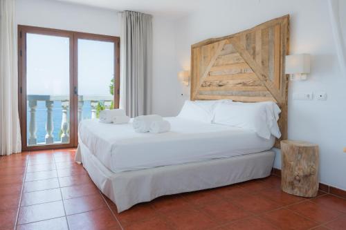 圣安东尼奥托雷伊维萨内格雷旅馆的卧室设有一张白色大床和一扇窗户。