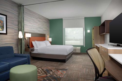 卡尔曼Home2 Suites By Hilton Cullman的一间酒店客房,配有一张床和一台电视