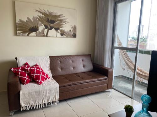 大普拉亚Ap aconchegante 12 min a pé p Praia的客厅里设有一张棕色沙发,配有窗户