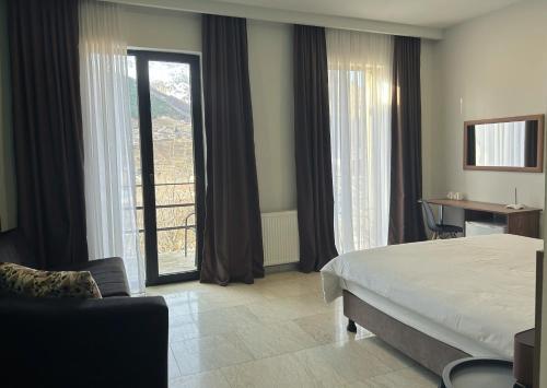 卡兹贝吉Shushabandi Kazbegi的酒店客房设有一张床、一张书桌和窗户。
