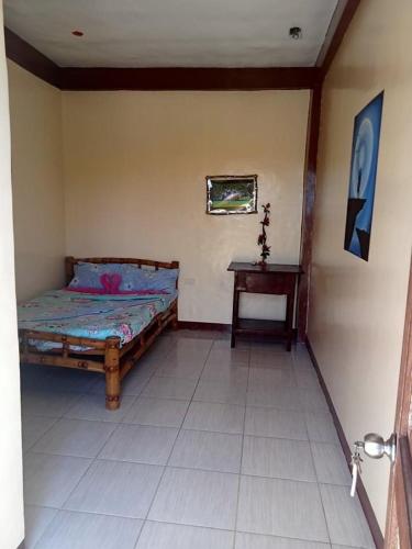 马拉帕斯加Malapascua Be One Guesthouse的一间卧室配有一张床和一张桌子