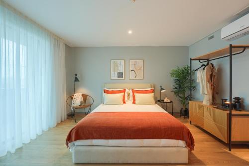 波尔图Icon Apartments by NÔMA的一间卧室配有一张大床和一个梳妆台