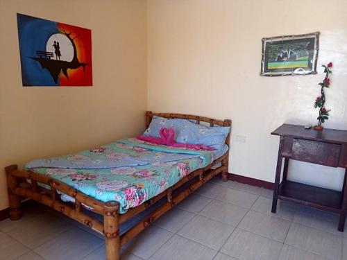 马拉帕斯加Malapascua Be One Guesthouse的一间卧室配有一张带粉色毯子的木床