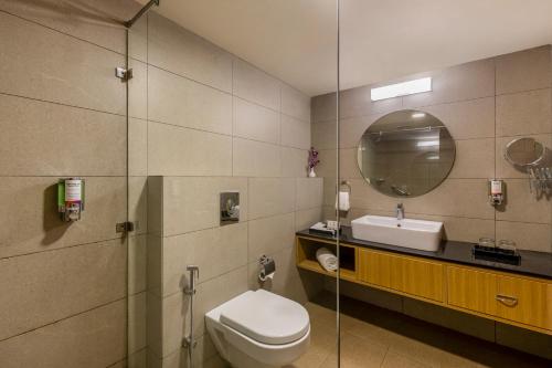 普里普里斯特林度假村的一间带卫生间、水槽和镜子的浴室