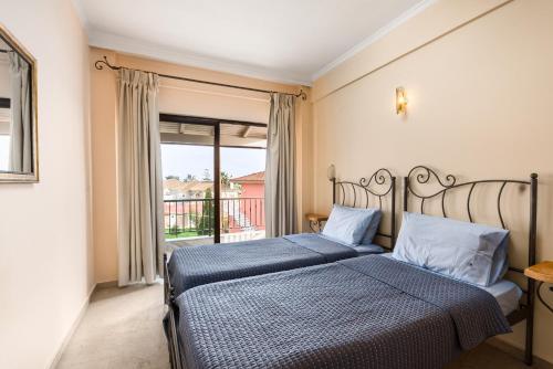 古维亚Marietta's Resort by Konnect, Gouvia Corfu的一间卧室设有两张床和大窗户