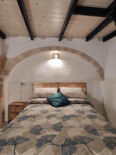 普蒂尼亚诺Archi Antichi的一间卧室设有一张带木制天花板的大床