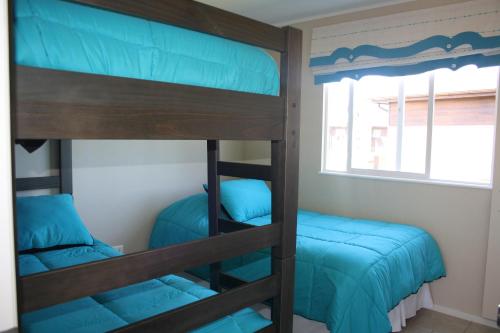 普孔Casa Pucon的双层床间 - 带两张双层床和一扇窗户