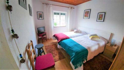 阿利若Quinta do Sol的卧室配有床、椅子和窗户。