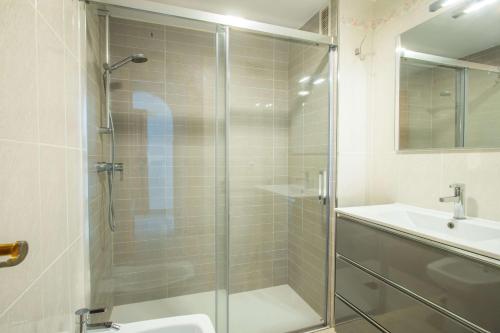 卡尔佩Apartamento Calpeplaya - PlusHolidays的一间带玻璃淋浴和水槽的浴室