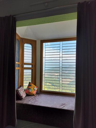 考萨尼Apna Ghar, Namasvi villa, c/o Anand singh bisht的窗户座位,房间设有大窗户和百叶窗