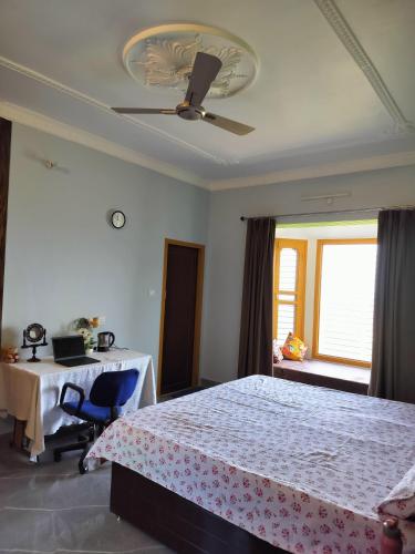 考萨尼Apna Ghar, Namasvi villa, c/o Anand singh bisht的一间卧室配有一张床、一张桌子和一个窗户。