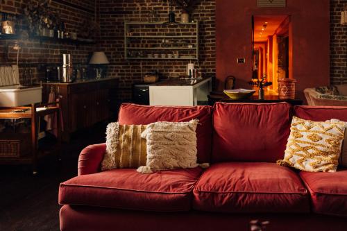 KentThe George & Heart House的客厅里配有红色沙发及枕头