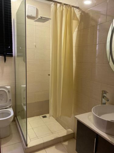 阿布贾Belhsreside的带淋浴、卫生间和盥洗盆的浴室