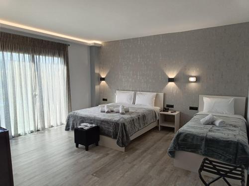纳弗帕克托斯Oikos 9 Rooms and Suites的一间卧室设有两张床和大窗户