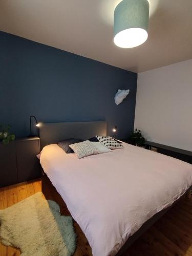 瓦尔代布洛尔Chalet de la Cianario的一间卧室配有一张白色大床和蓝色的墙壁