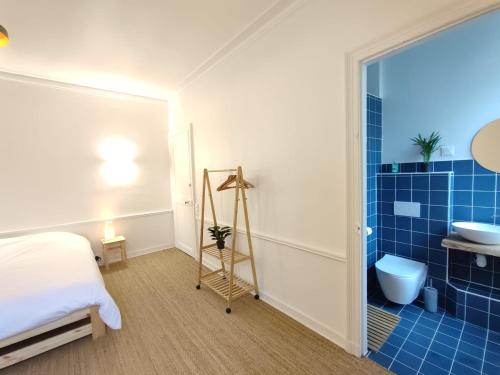 卢瓦尔河畔圣塞巴斯蒂安Le manoir de la Plume 10min de Nantes centre ville的一间卧室,配有带水槽和卫生间的浴室