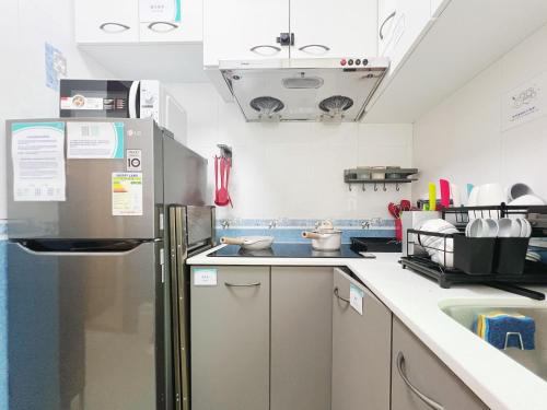 香港Student Accommodation - 26 Man Yuen Street的厨房配有冰箱和水槽