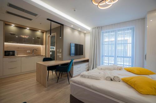 科什保尔洛格Szent Orbán Erdei Wellness Hotel的一间带一张床和一张书桌的卧室和一间厨房