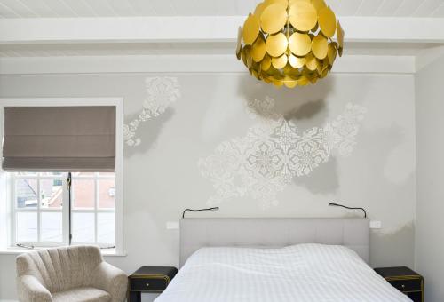 埃尔斯佩特Herberg de Zwaan Elspeet的一间卧室配有一张床和一个金色吊灯