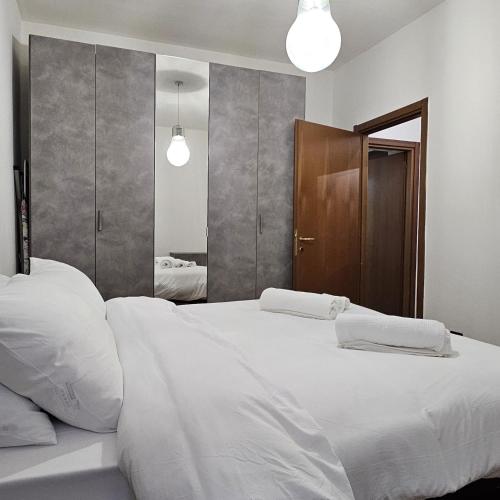 奥尔贾泰奥洛纳Casa Moderna Olgiate的一间卧室配有两张白色的床和镜子