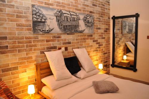 SenchiSanta Monica Home Lodge的一间卧室设有砖墙和一张带枕头的床