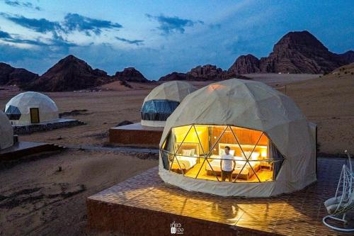 瓦迪拉姆Aljawhara camp and activities的站在沙漠圆顶帐篷中的男人