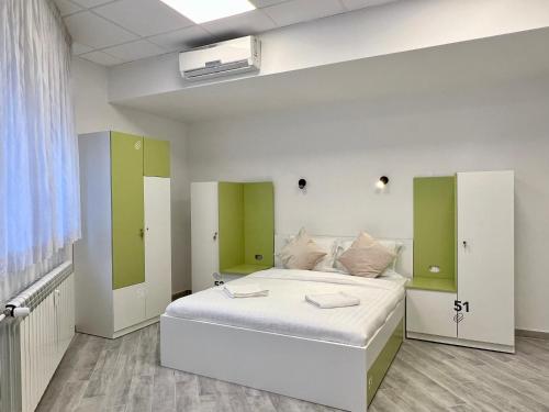 萨格勒布Appa Hostel的一间卧室配有一张绿色的白色床。