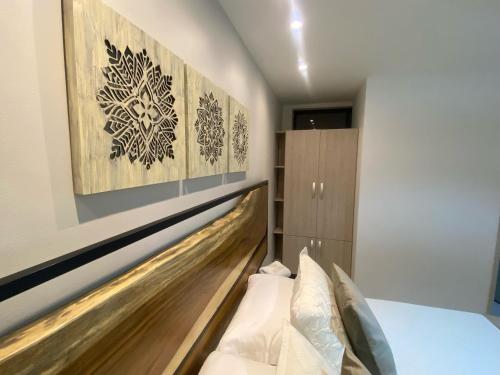 麦德林Maidy Luxury的一间卧室配有一张带木制床头板的床