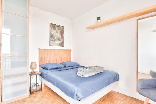 巴黎BEL APPARTEMENT PARISIEN PARC MONTSOURIS的一间卧室配有一张带蓝色床单的床和一把椅子
