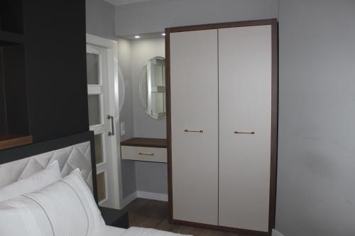 安塔利亚Cosy suites hotel的卧室配有白色衣柜和白色床。