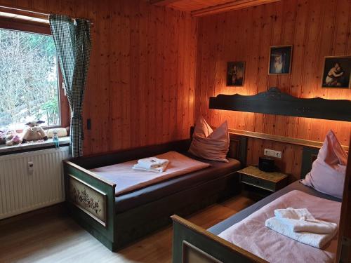 SchöfwegUriges Apartment + Schönblick + mitten im Bayerischen Wald + WLAN kostenfrei的配有窗户和床罩的客房内的两张床