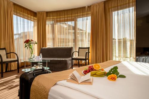 索非亚欧洲酒店的酒店客房,配有一张带书籍和水果的床。