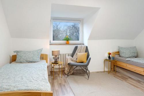 基尔Kiel Elmschenhagen Ostufer的卧室配有床、椅子和窗户。