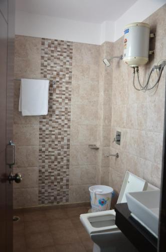 诺伊达Rumaisa Red的带淋浴、卫生间和盥洗盆的浴室