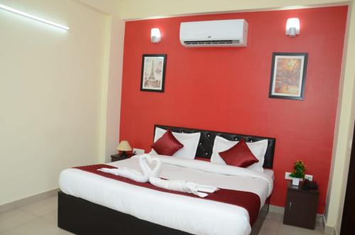 诺伊达Rumaisa Red的卧室设有一张红色的墙壁和一张床