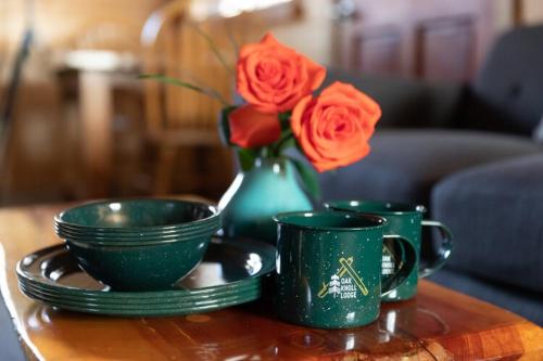 大熊湖2401 - Oak Knoll Studio with Jacuzzi #2 cabin的一张桌子,上面有两个绿杯和一个玫瑰花瓶