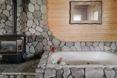 大熊湖2401 - Oak Knoll Studio with Jacuzzi #2 cabin的石墙客房内的浴缸