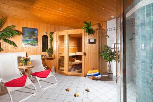 贝希特斯加登Pension Rennlehen的一间设有白色椅子和桌子的房间,以及木制天花板