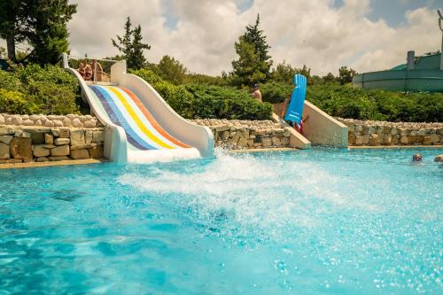 阿萨拉尔AQI Pegasos Resort的一个带彩虹的游泳池的水滑梯