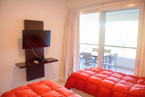 埃斯特角城Solanas Green park resort and spa Vacation Club的一间卧室配有一张床、一台电视和一个阳台