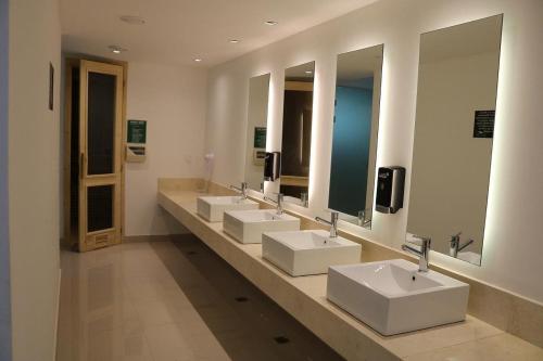埃斯特角城Solanas Green park resort and spa Vacation Club的浴室设有4个水槽和一排镜子