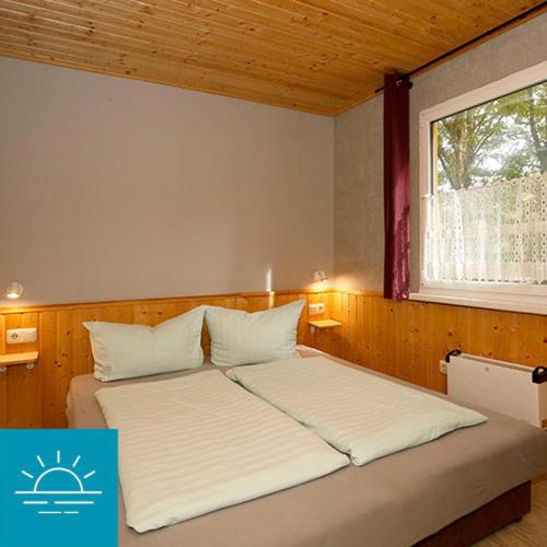 德兰斯克Bungalow SONNE UND MEER direkt am Strand的一间卧室设有两张床和窗户。