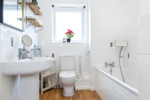 曼彻斯特Cozy Townhouse in the heart of Greater Manchester的白色的浴室设有水槽和卫生间。