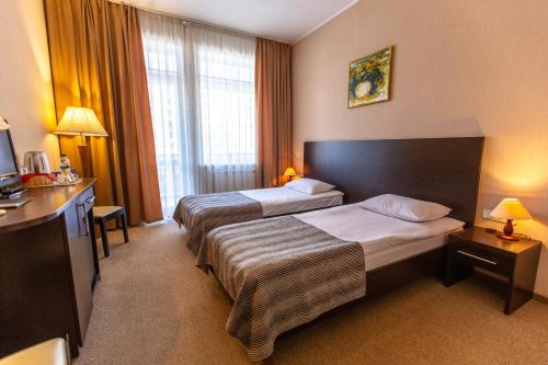 波尔塔瓦Аполлонія的酒店客房设有两张床和窗户。
